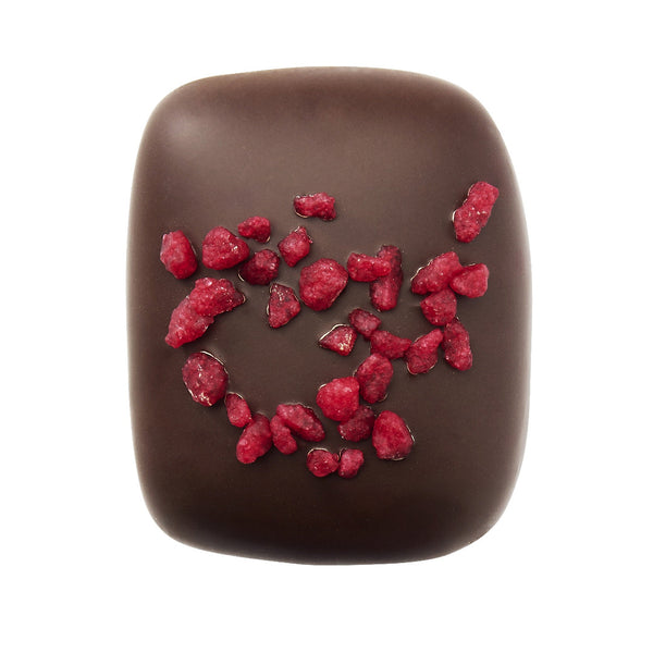 Manon Raspberry, pralină fructată și delicioasă, cremă de unt cu zmeură, așezată delicat  pe un strat de cremă pralinată crocantă. Toată acoperită cu ciocolată neagră și presărată cu bucăți de zmeură