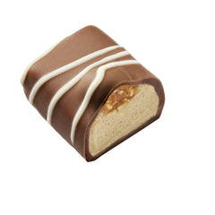  Manon Nougatina,o pralină senzuală cu cremă de unt cu alune de pădure, cremă pralinată și o perlă crocantă de nugatină, învelită în ciocolată cu lapte cu dungi de ciocolată albă