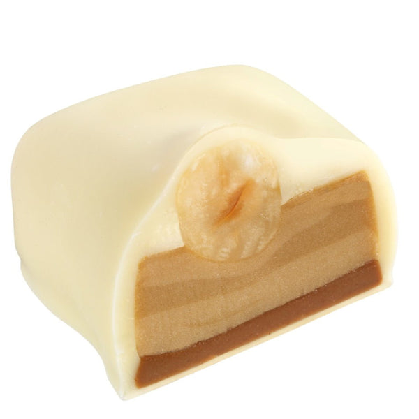 𝐌𝐚𝐧𝐨𝐧 𝐂𝐚𝐟𝐞́ 𝐰𝐡𝐢𝐭𝐞 -înveliș fin din ciocolată albă cu umplutură delicioasă: cremă de unt infuzată cu cafea Arabică 100%, așezată peste un strat subțire de cremă pralinată, acoperită cu o alună de pădure întreagă