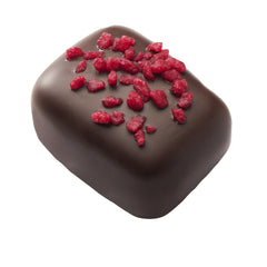 Manon Raspberry, pralină fructată și delicioasă, cremă de unt cu zmeură, așezată delicat  pe un strat de cremă pralinată crocantă. Toată acoperită cu ciocolată neagră și presărată cu bucăți de zmeură